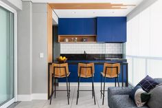 a kitchen with blue cabinets and counter tops next to a living room area that also has a couch