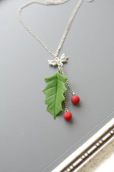 "Holly necklace pendant, Christmas necklace, Christmas jewelry, Christmas gifts, Holiday necklace, Leaf necklace This is a beautiful Christmas inspired charm necklace! The charm cluster pendant includes a realistic handsculpted leaf and berrys from polymer clay. This is a beautiful Christmas collection of nature inspired charms and make a fun and interesting accessory for spicial day! The pendant measures approx. 2.5\" (6-7cm) and hangs from a nickel free chain and has a high quality lobster cla Holiday Necklace, Christmas Necklace, Cluster Pendant, Leaf Jewelry, Christmas Gift Jewelry, Holiday Jewelry, Leaf Necklace, Christmas Jewelry, Red Christmas