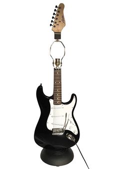 an electric guitar is sitting on top of a black stand with a microphone attached to it