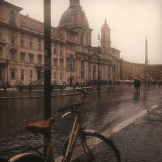 a bicycle parked on the side of a wet street