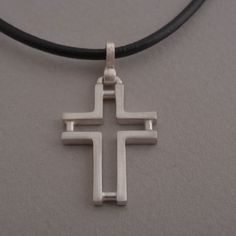 Minimal line and ingenious design characterize this beautiful sterling silver cross pendant necklace for men or women. The effect is minimalistic, yet alluring. Suspended from a silver chain or leather cord with silver clasp and endings, it is a stylish accessory for anyone that wants to keep their faith close to their heart and share it for the world to see. This also makes a stunning Christian gift for a special person in your life. Cross measures 3.8 cm x 2 cm. You get the cross with a 48 cm Minimalist Silver Cross Necklace, Modern Silver Necklace With Cross Pendant, Modern Crucifix Cross Necklace As Gift, Minimalist Sterling Silver Cross Pendant Necklace, Modern Sterling Silver Cross Pendant Jewelry, Modern Sterling Silver Cross Pendant, Modern Silver Cross Pendant Necklace, Modern Crucifix Necklace As Gift, Modern Cross Necklace As A Gift