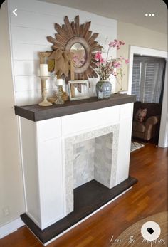 a white fireplace with a mirror above it