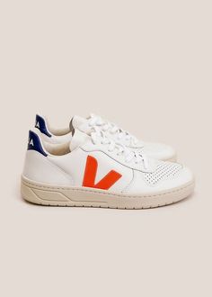 White v-10 sneakers featuring a chunky rubber sole  veja's signature v logo in orange-fluo and a cobalt blue back.    mindfully and ethically crafted in a high-standard factory in porto alegre brazil (a well-developed region in south brazil) which has good working and living conditions respect of worker dignity and effective trade union representation.    material  upper leather. v logo made of rubber and 23% rice waste. soft inner lining 33% organic cotton and 67% recycled plastic bottles. inso South Brazil, Veja V 10, V Logo, Trade Union, Blue Back, Sugar Cane, Ethical Clothing, Recycled Rubber, Hummel Sneaker