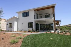 a large white house sitting on top of a lush green field