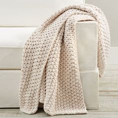 a crocheted blanket sitting on top of a white couch