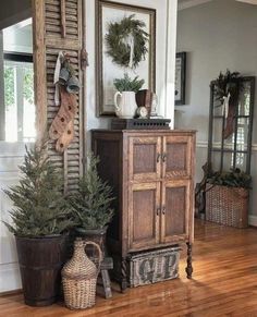 two potted plants sit on top of a wooden cabinet in front of a mirror