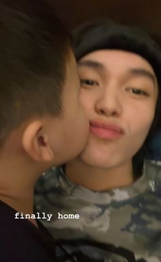 a young boy is kissing his friend's cheek with the caption finally home