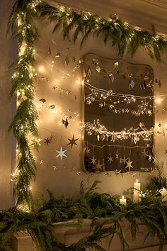 a mantle with christmas lights and garland on it