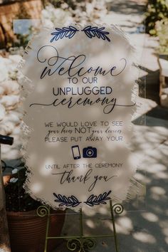 a welcome sign is displayed in front of a potted plant