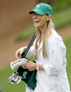 a woman in white jacket and hat holding a baseball bat with glove on her shoulder