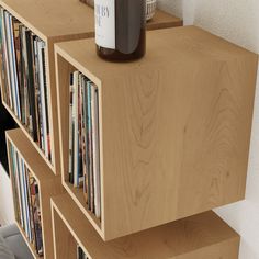 a wooden shelf with several cd's and a bottle of wine sitting on top of it