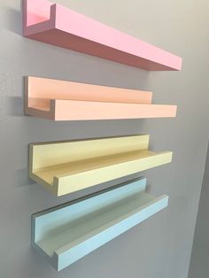 three different colored shelves are hanging on the wall