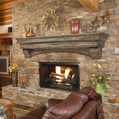 a living room with a fire place and couches in front of a stone fireplace