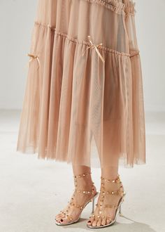 Enhance your summer style with our Beautiful Khaki Bow Ruffled Tulle Skirts. The delicate tulle material creates a romantic and feminine look, while the bow detail adds a touch of luxury. Perfect for any special occasion or a day out on the town, these skirts are a must-have for any fashion-forward woman. Fabric: TulleSize & Fit: This garment fits true to size.Length: Size M measures 31.2"from waist to hem.Waist:Fitted - elastic waist allows stretch Hip: Loosely Fitted. room for hips. Chic Tiered Sheer Skirt, Chic Sheer Tiered Skirt, Summer Balletcore Petticoat With Ruffles, Long Summer Party Skirt, Summer Party Long Skirt, Summer Balletcore Dress With Ruffled Skirt, Feminine Pleated Tulle Skirt, Spring Tiered Tulle Skirt Dress, Spring Tulle Tiered Skirt Dress