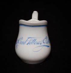 a small white cup with blue writing on it