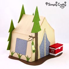 an origami house with trees on the roof and a red truck behind it