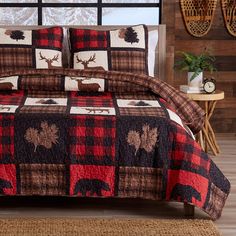 a bed covered in a red and black checkered comforter with moose on it