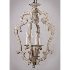 a chandelier with candles hanging from it's center and an intricately carved design