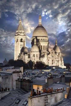 an image of a cathedral in the sky with clouds above it and rooftops below