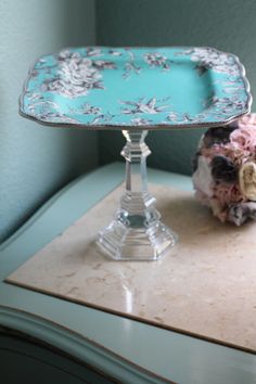 a blue and white tray sitting on top of a table next to a flower arrangement