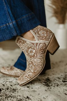 Elevate your style with our Western Moxie Hand-tooled Booties. Hand-crafted from rich white and chocolate-hued leather, these booties feature classic cowboy heels and stylish side slits for easy wear. The intricate hand-tooled design, inspired by desert blossoms, adds a touch of Western sophistication to any outfit. Plus, with a unique traditional pattern, these booties are sure to stand out. Size down for the perfect fit! Tooled Leather Boots, Woman’s Cowboy Boots, Western Booties With Dress, Cowboy Fashion Womens, Women’s Western Boots, Boujee Cowgirl Outfits, Western Shoes Womens, Wedding Booties For Bride, Cowboy Christmas Outfit