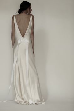 the back of a woman's wedding dress with a white sash around her waist