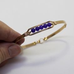 A sweet little bracelet of five strands of 14kt gold filled wire with a center design featuring five 4mm genuine amethyst beads and accented with two smaller beads. Perfect for that February birthday girl! Stackable, too, along with many of my other wirewrapped bracelets! The sturdy built-in hook and eye clasp is easy to get on and off by yourself. Choose the size you need for a comfortable custom fit. Also available in sterling silver. Gold Hand-wrapped Bracelets For Gifts, Hand Wrapped Gold Bracelets As Gift, Hand Wrapped Gold Bracelets For Gift, Friendship Hand Wrapped Bangle Bracelet, Dainty Adjustable Wire Wrapped Beaded Bracelets, Adjustable Dainty Gold Bangle Bracelet, Gold Hand Wrapped Friendship Bracelets As Gift, Elegant Wire Wrapped Crystal Bangle Bracelet, Elegant Wire Wrapped Crystal Bangle