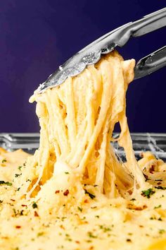 a fork is lifting up some food out of the casserole dish with cheese and parmesan