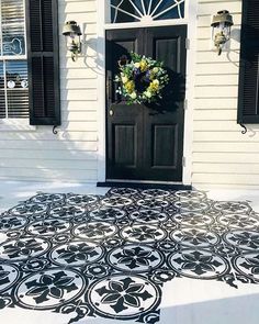 a black and white rug on the ground in front of a door with shutters