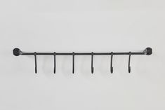 a metal rack with five hooks on it