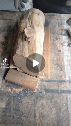 a piece of wood sitting on top of a wooden floor next to a pile of logs