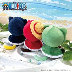 three stuffed animals sitting next to each other on a white cloth covered table with plants