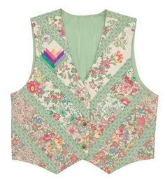 a vest with flowers on it and a rainbow patch in the back, sitting on a white surface