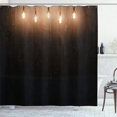 a bathroom with a shower curtain that has lights on it and a chair in front of it