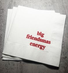 two white napkins with the words big friendsmas energy printed on them, sitting next to each other