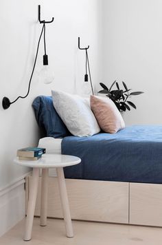 a bed room with a neatly made bed and two hooks on the wall above it