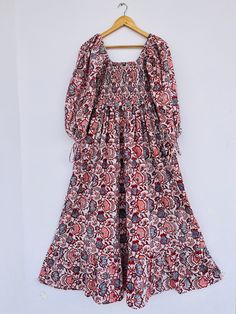 "Cotton maxi, hand block print dress, red printed dress, boho dress, boho maxi, long maxi, smocking maxi dress, bobbin dresses, cotton dresses, vintage gown, smocked maxi, hippie dresses, gauze maxi, gift for her, gift for mom, Christmas gift, festival wear, customised dresses,  fast shipping, summer dress, red flower dress Feel beautiful and confident throughout your days wearing our block printed outfits, made with high quality soft and breathable cotton fabric.  The print on the dress is known as \"BLOCK PRINT\" which is centuries old technique of Indian textile carried out  by local artisans of Jaipur (INDIA) MEASUREMENTS (in inches): Size XXS-: Bust- 34″ | Shoulder- 13.5″ | Length- 51″ Size XS-: Bust- 36″ | Shoulder- 14″ | Length- 51″ Size S-: Bust- 38″ | Shoulder- 14.5″ | Length- 51″ Traditional Boho Maxi Dress With Floral Print, Bohemian Smocked Midi Dress, Red Bohemian Floral Dress, Traditional Maxi Dress With Floral Print, Cotton Smocked Maxi Dress, Red Cotton Maxi Dress With Block Print, Red Batik Print Maxi Dress, Red Bohemian Dress With Kalamkari Print, Bohemian Red Dress With Kalamkari Print