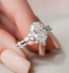 a woman's hand holding an engagement ring with a large diamond in the middle