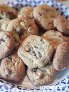 a plate full of chocolate chip cookies on top of a blue and white table cloth