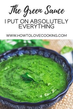 a bowl filled with green sauce on top of a table