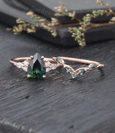 a green ring with leaves on it sitting on top of a wooden table next to a twig