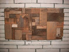 a piece of wood that has been made into a wall hanging on a brick wall