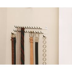 there is a rack with ties hanging on the wall next to other tie racks and hooks