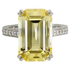 A magnificent engagement ring showcasing a long emerald cut yellow sapphire, set in a diamond encrusted basket and shank. Made in platinum. Yellow Sapphire weighs 11.06 carats. Size 6 US (sizable) Dimensions: 0.62 in x 0.42 in. Sapphire Emerald Ring, Flower Halo Engagement Ring, Sapphire And Diamond Engagement Ring, Timeless Engagement Ring, Diamond Sapphire Engagement Ring, Emerald Cut Diamond Engagement, Contemporary Engagement Rings, Emerald Cut Diamond Ring, Platinum Diamond Engagement Rings