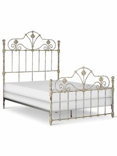 an antique style metal bed frame with white sheets