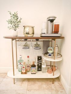 a bar cart with liquor bottles and glasses on it