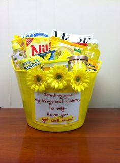 a yellow bucket filled with lots of goodies sitting on top of a wooden table