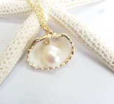 Beautiful gold sea shell necklace made with a gold plated seashell charm with a gold filled chain and fresh water pearl. This necklace makes a unique gift for a beach lover or someone special in your life. The seashell is around 15- 20mm long. Each item is carefully packaged in a beautiful jewellery box ready as a gift. If you would like to add a personalized note with your order, just write a note at checkout and I will send a small card with your gift to the recipient. Please choose necklace l Handmade Gold Shell Strand, Handmade Gold Strand Shell, Ocean-inspired Pearl Charm Jewelry For Gifts, Ocean-inspired Pearl Charm Jewelry As Gift, Ocean-inspired Pearl Charm Jewelry Gift, Gold Strand Jewelry For Gift, Pearl Shell Necklace For Gifts, Pearl Shell Necklace For Gift, Pearl Charm Strand Jewelry Gift