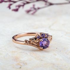 a close up of a ring on a table with flowers in the background and a branch behind it