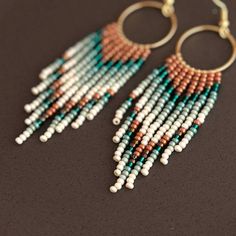 Embrace the spirit of bohemian flair with these captivating fringe beaded hoop earrings. Featuring a stunning interplay of turquoise and burnt orange beads, they cascade playfully from high-quality, lightweight hoops. Each meticulously handwoven bead adds to the unique and vibrant design, ensuring these earrings become cherished conversation starters. More than just an accessory, these earrings are testaments to artisan skill.  The intricate beadwork and high-quality materials elevate them beyon Turquoise Bohemian Beaded Fringe Earrings, Bohemian Turquoise Tassel Earrings With Beaded Fringe, Bohemian Chandelier Earrings With Fringe And Round Beads, Bohemian Hoop Earrings With Tiny Beads, Bohemian Fringe Dangle Hoop Earrings, Bohemian Dangle Fringe Hoop Earrings, Bohemian Dangle Jewelry With Beaded Fringe, Burnt Orange Accents, Fringe Earring Pattern